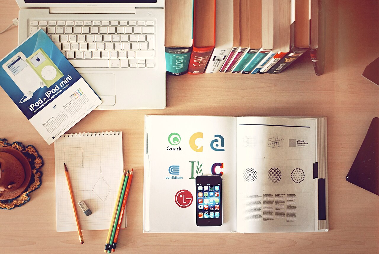 Escritorio de trabajo con portátil, móvil y libretas