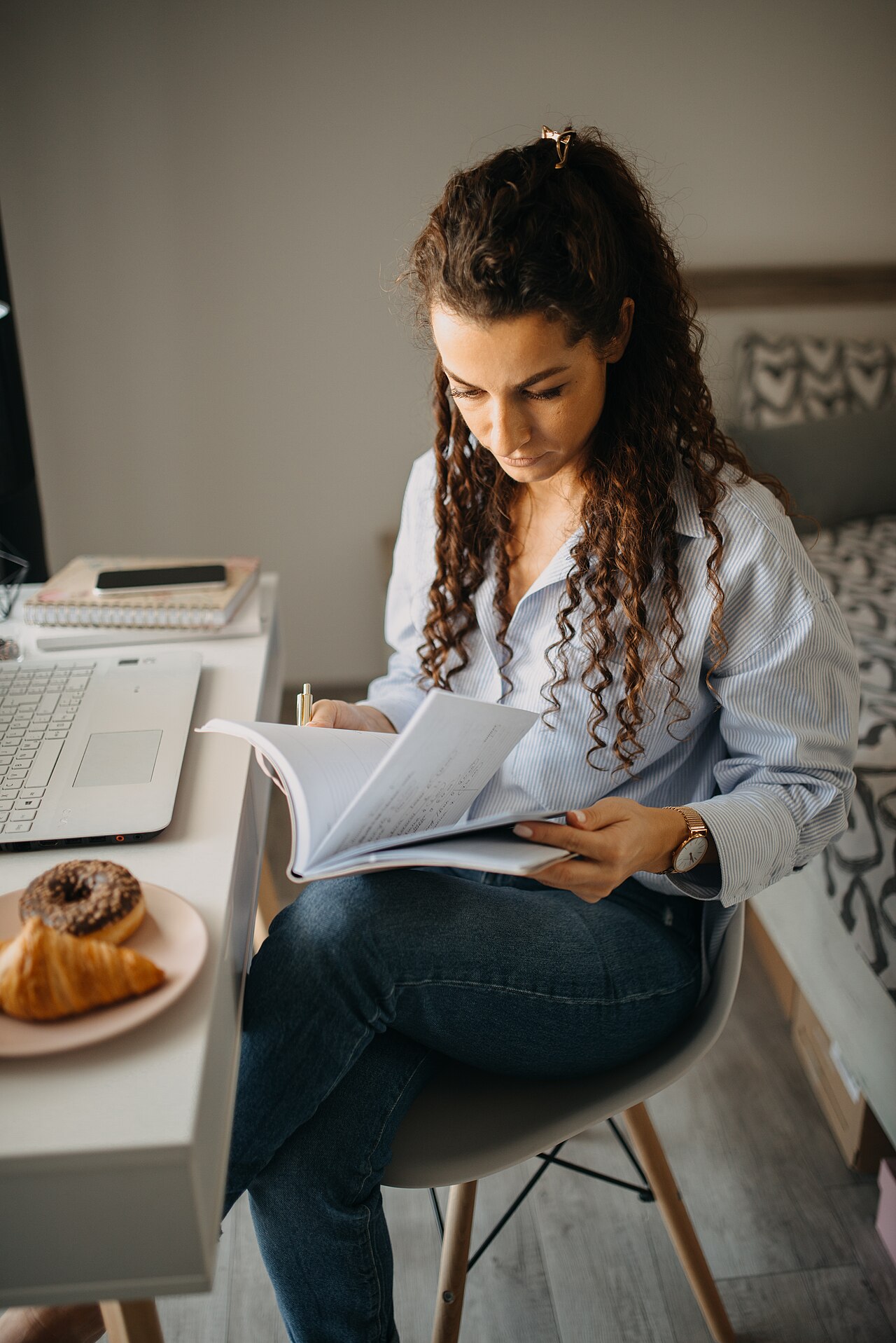 Chica estudiando con un portátil en su escritorio